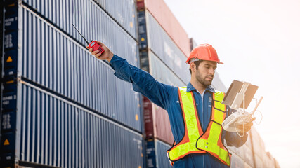 A foreman or worker pilots a drone at a container port used a remote controller for checking container.
