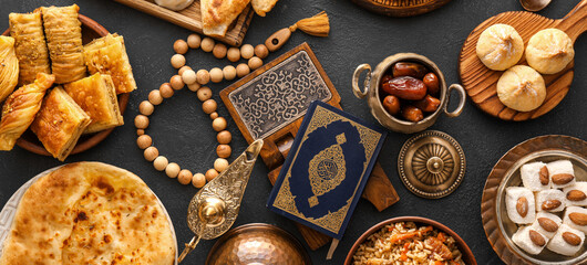 Traditional Eastern dishes with Quran, Arabic lamp and tasbih on dark background