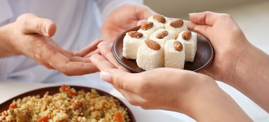 Muslim couple having breakfast together at home. Celebration of Eid al-Fitr