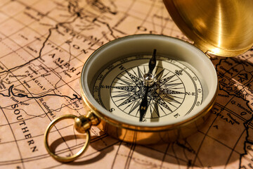 Fototapeta na wymiar Vintage golden compass on world map, closeup