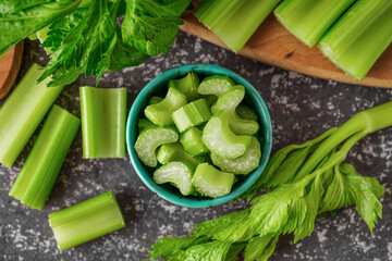 Bowl of fresh cut celery on grunge background