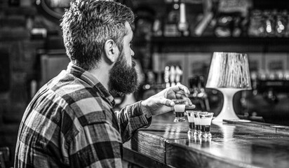 Drinking alcohol into shot glasses in a nightclub or bar. Bearded man shots cocktail. Tequila...
