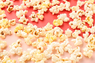 Tasty popcorn scattered on color background, closeup