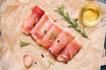Baking paper with slices of tasty ham, spices and oil, closeup