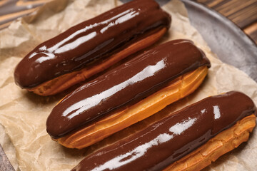 Plate with delicious chocolate eclairs, closeup