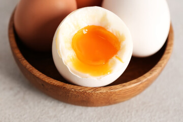 Bowl with soft boiled eggs on grey table