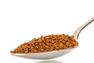 Fragrant instant coffee in a metal spoon, macro, isolated on white background.