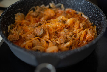 Stewed cabbage in a frying pan. Cooking recipe.