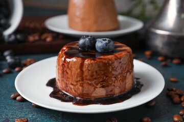 Plate with delicious pudding, chocolate sauce and blueberry on table
