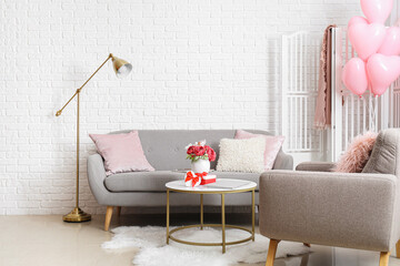 Interior of living room with sofa, armchair and pink balloons for Valentine's Day
