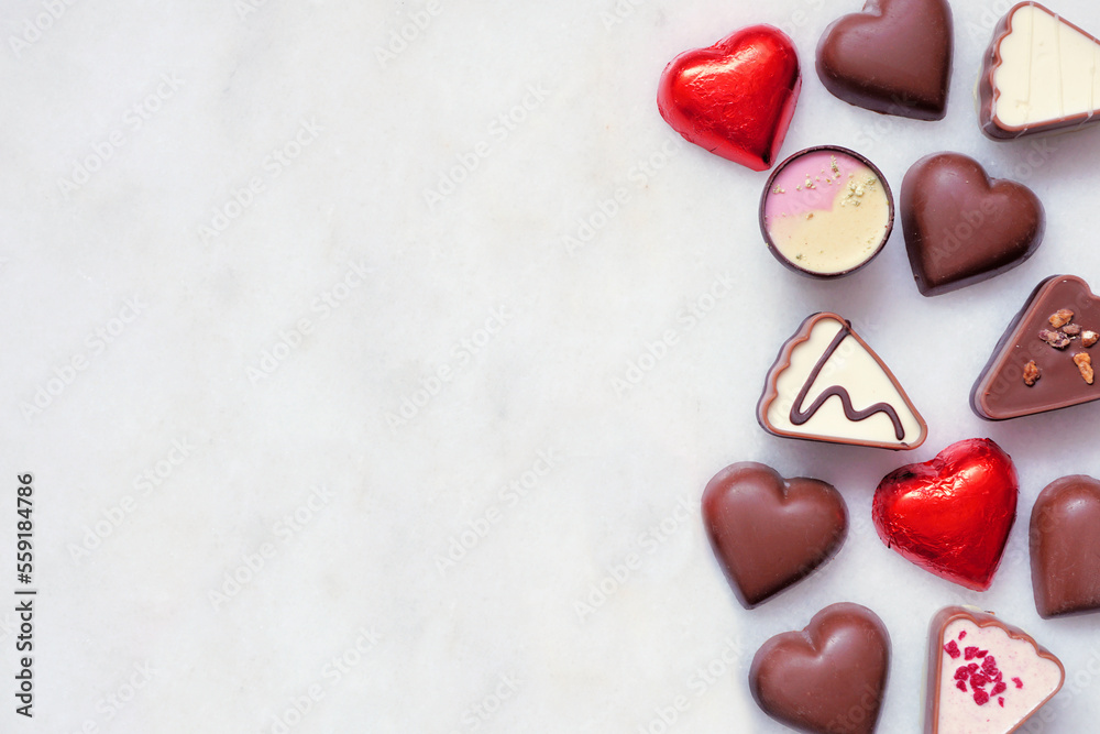 Poster valentines day chocolate side border. red and pink heart theme. top down view on a white marble back