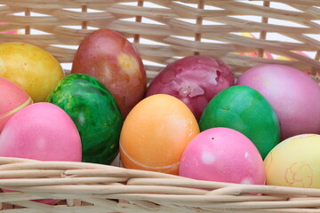 Basket with colorful Easter eggs on white background