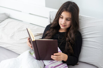 Fototapeta na wymiar teenage girl with a book in bed
