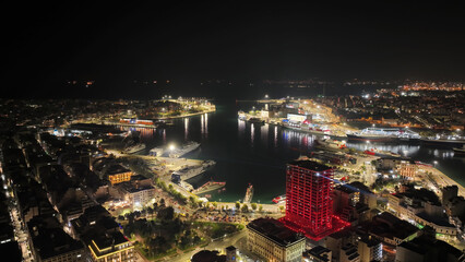 Obraz premium Aerial drone night shot of illuminated tower and port of Piraeus during New Year's eve celebrations, Attica, Greece
