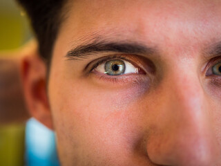 Close-up of attractive young man's green eye