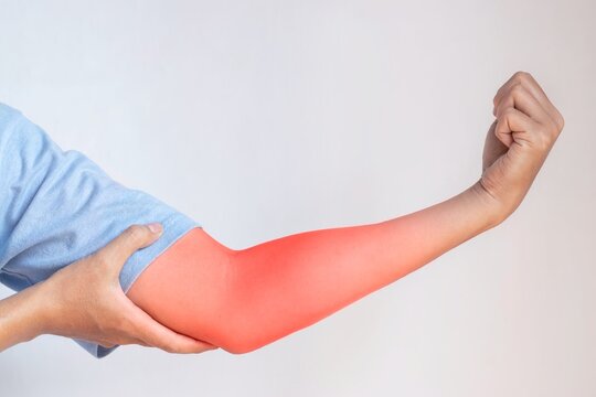 Pain in the upper arm of Southeast Asian young man. Concept of elbow  and forearm pain, injury or muscle problem.