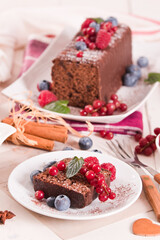 Fototapeta na wymiar Chocolate sponge cake with fresh fruit on white dish.