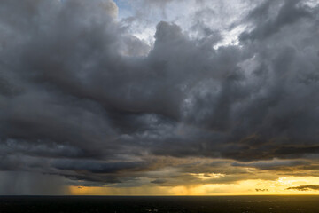 Cumulonimbus clouds forming before thunderstorm on evening sky. Changing stormy cloudscape weather at sunset