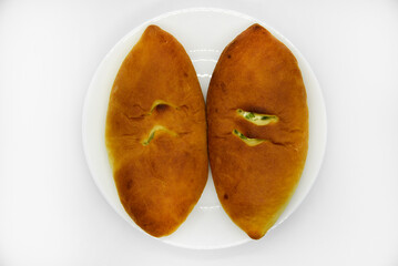 Two delicious pies on a plate. Pies with stuffing. Flour pies with potatoes.