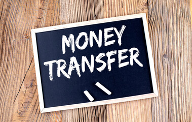 MONEY TRANSFER text on chalkboard on the wooden background