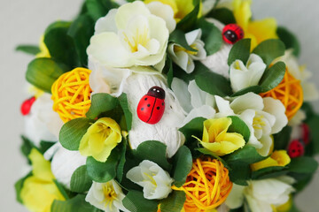Bright floral part close-up spring topiary with ladybird in the center and yellow rattan balls horizontally