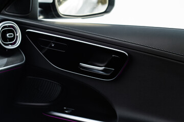 Plakat Modern car interior door handle close up. Metallic Car door opener handle inside.
