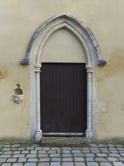 Fototapeta premium Entrance door with holy water stoup of Notre-Dame des Mariniers chapel in Saint Symphorien d'Ozon, France 