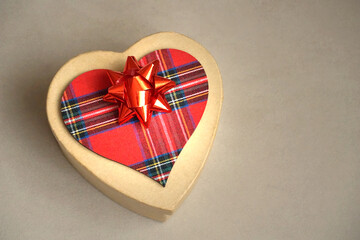 Gift box with red bow and red tartan Scottish pattern heart