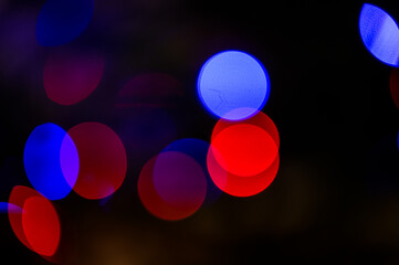 Background full of unfocused colored lights. Blurred traces of lights and spots of Christmas tree.