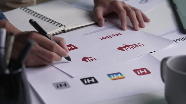 Graphic designer drawing sketches logo design. The concept of a new brand. Professional creative occupation with idea.