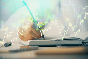 Multi exposure of woman's hands making notes with forex graph hologram. Concept stock market analysis.