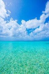 blue sky with scattered clouds and crystal clear turquoise ocean water