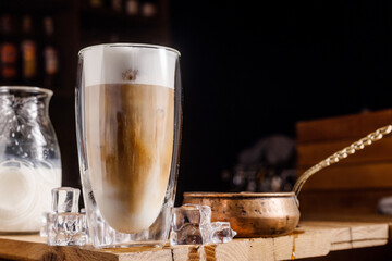 coffee drink with cream and ice on a dark wooden background