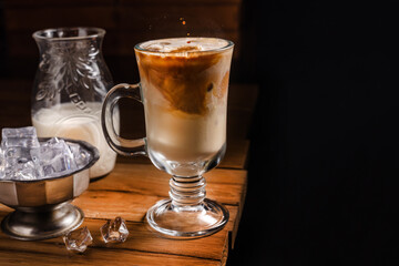 coffee drink with cream and ice on a dark wooden background