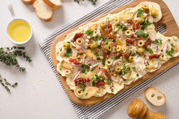 Trendy Butter Board with olives, sun-dried tomatoes, nuts, thyme, red onion and herbs with crispy...