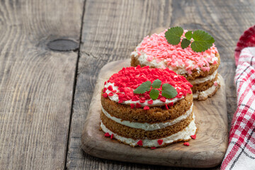Homemade layered dessert with whipped cream and heart shaped sprinkles on wooden table
