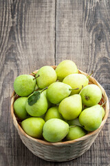 Juicy yellow pears in basket on wooden table