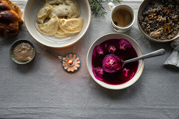 Essential Ukrainian Christmas Eve supper dishes - borsch with vushka (porcini dumplings), varenyky, kutia, uzvar on linen tablecloth.  