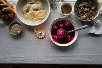 Essential Ukrainian Christmas Eve supper dishes - borsch with vushka (porcini dumplings), varenyky, kutia, uzvar on linen tablecloth.  