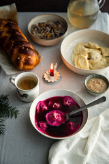 Essential Ukrainian Christmas Eve supper dishes - borsch with vushka (porcini dumplings), varenyky, kutia, uzvar on linen tablecloth.  