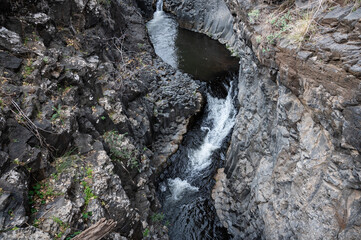 Mountain stream Meshushim. Nahal Meshushim. Rocks in the form of hexagonal basalt columns.