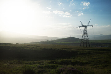 Power lines on the plain, mountains in the background, technical communications and nature.