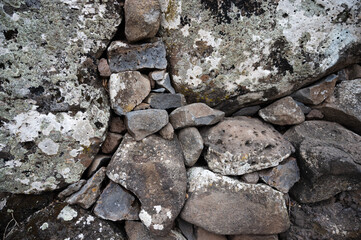 Fototapeta premium Closeup of large rocks or boulders near the mountains. Large multicolored granites. Details of big grey stone structures with orange particles shining in the sunlight.