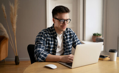 A man in a shirt and glasses, a webinar or a training course or a computer, studies online from...