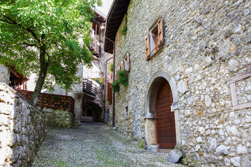 Fototapeta na wymiar The medieval village of Canale di Tenno, Trentino-Alto Adige, Italy: a narrow lane through tunnel arches