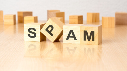 four wooden blocks with text SPAM on table. copy space. white background.