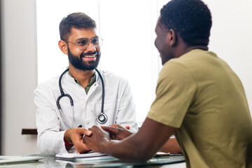 Portrait of indian man doctor talking to patient on consultation