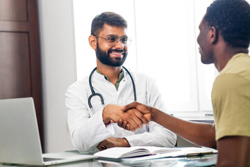 Fototapeta premium Portrait of indian man doctor talking to patient on consultation
