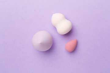 Beauty blenders on color background, top view
