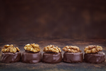 Close up of homemade with dark chocolate pralines filled with walnuts and  marzipan